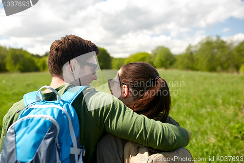 Image of happy couple with backpacks hiking outdoors