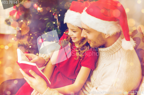 Image of smiling father and daughter reading book