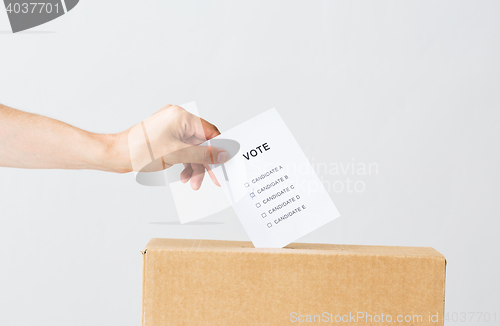 Image of man putting his vote into ballot box on election