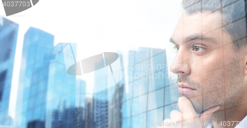 Image of close up of male face over office buildings