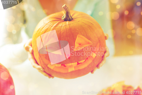 Image of close up of woman with pumpkins at home