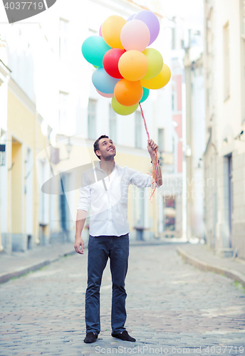 Image of man with colorful balloons in the city