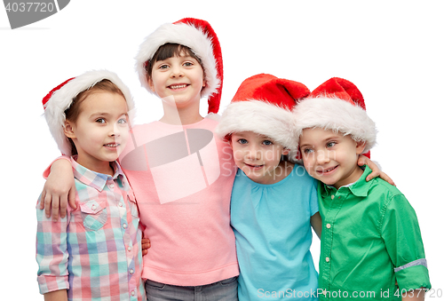 Image of happy little children in santa hats hugging