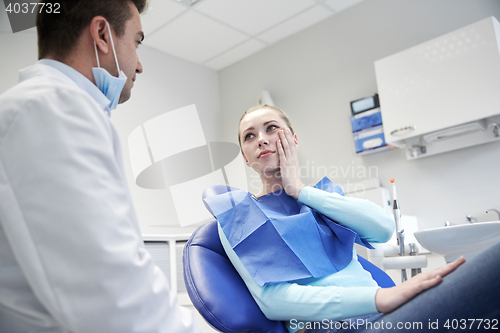 Image of male dentist with woman patient at clinic