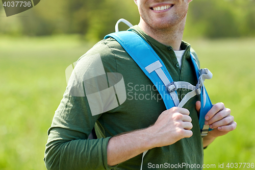 Image of close up of happy young man with backpack hiking