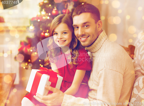 Image of smiling father and daughter holding gift box