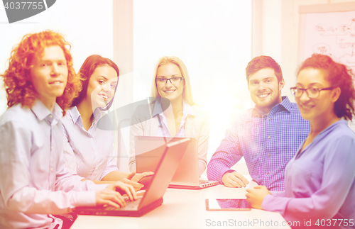 Image of smiling team with laptop and table pc computers