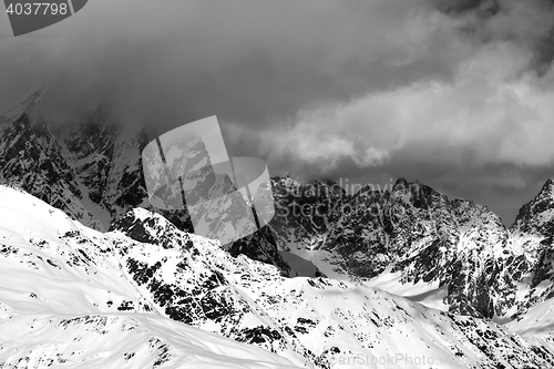 Image of Black and white snowy rocks in clouds at sunny day