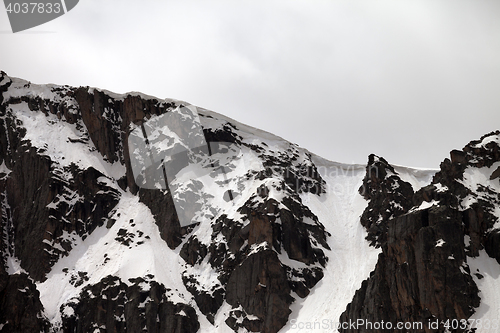 Image of Rocks with snow cornice in gray day