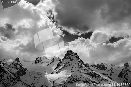 Image of Black and white view on evening mountains in sunlight clouds