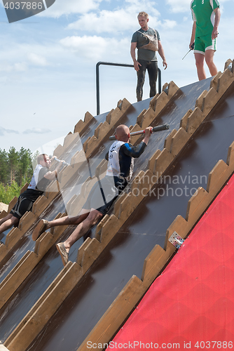 Image of Athlete gets on inclined wall by means of bar