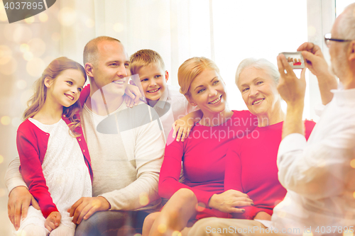 Image of smiling family with camera at home