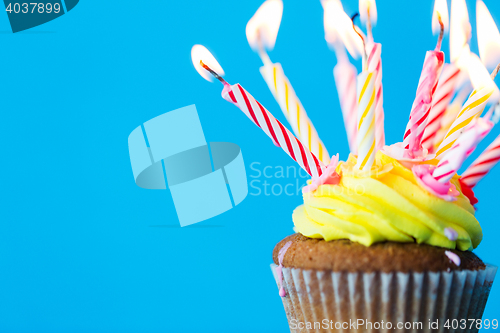 Image of birthday cupcake with many burning candles