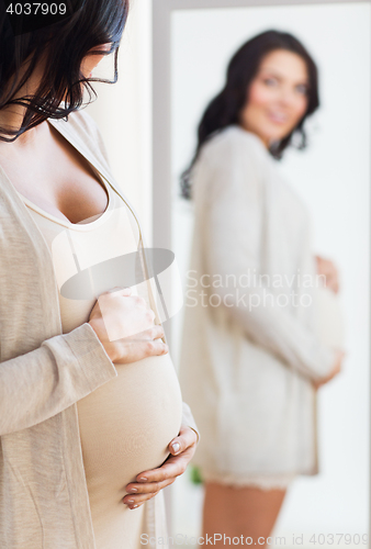 Image of close up of pregnant woman looking to mirror