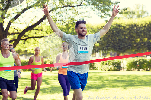 Image of happy young male runner winning on race finish