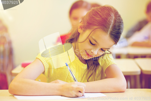 Image of group of school kids writing test in classroom