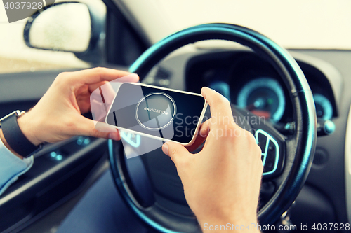 Image of hands with navigator on smartphone in car