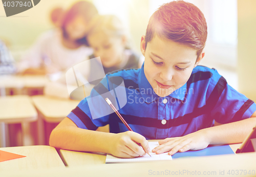 Image of group of school kids writing test in classroom