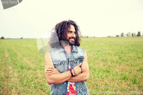 Image of smiling young hippie man on green field