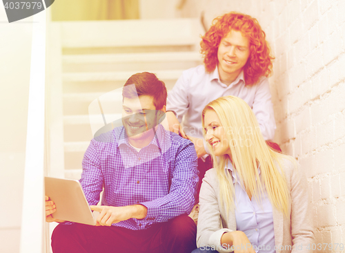 Image of team with tablet pc computer sitting on staircase