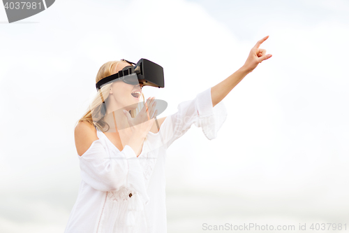 Image of woman in virtual reality headset pointing finger