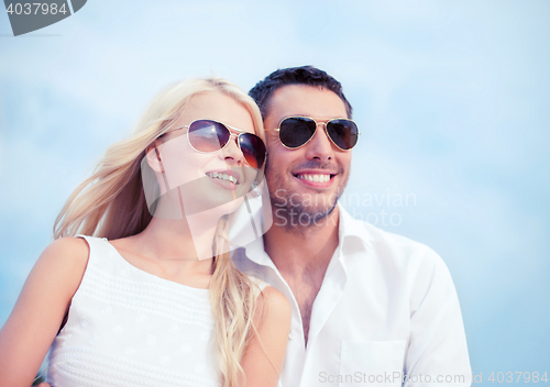 Image of couple in shades at sea side