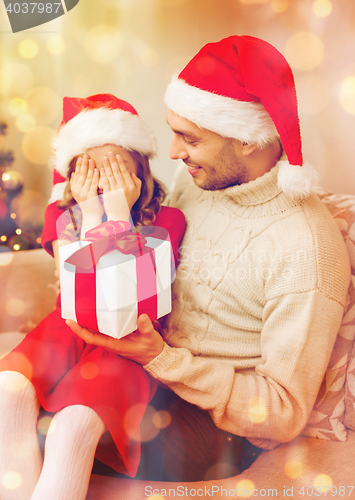 Image of smiling daughter waiting for a present from father