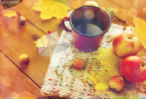 Image of close up of tea cup on table with autumn leaves