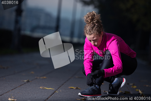 Image of woman  stretching before morning jogging