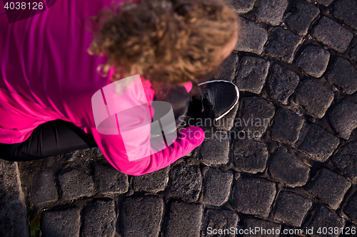 Image of woman  stretching before morning jogging
