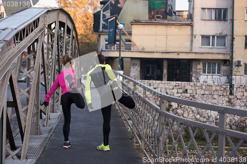 Image of couple warming up before jogging