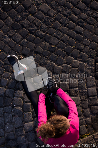 Image of woman  stretching before morning jogging