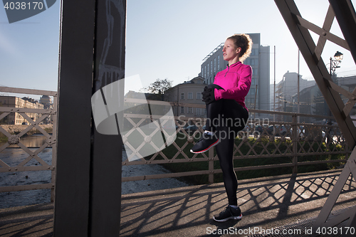 Image of woman  stretching before morning jogging