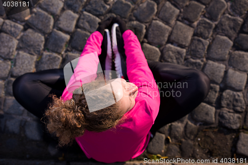 Image of woman  stretching before morning jogging