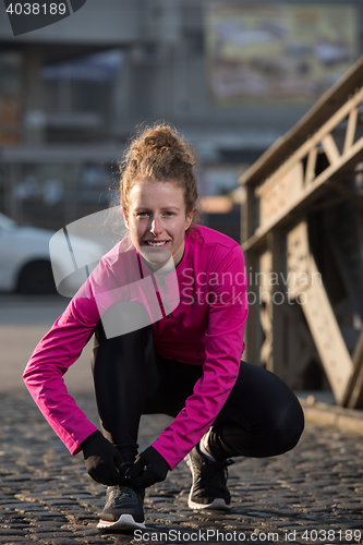 Image of woman  stretching before morning jogging