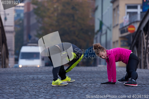 Image of couple warming up before jogging