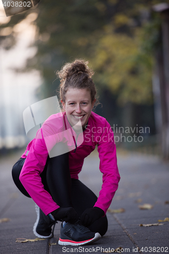 Image of woman  stretching before morning jogging