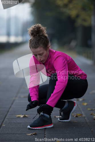 Image of woman  stretching before morning jogging