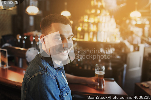 Image of happy man drinking beer at bar or pub