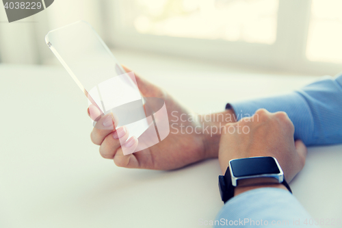 Image of close up of hands with smart phone and watch