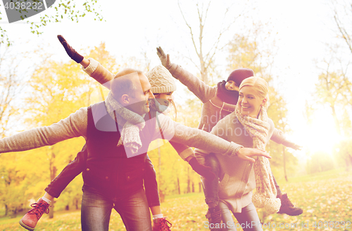 Image of happy family having fun in autumn park