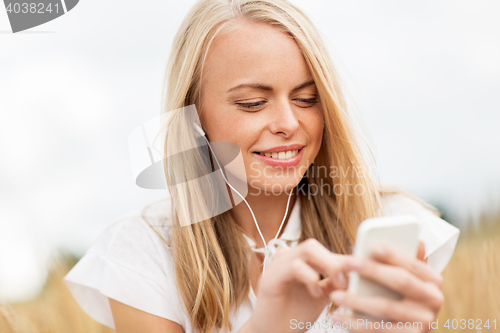 Image of happy woman with smartphone and earphones