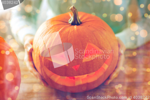 Image of close up of woman with pumpkins at home