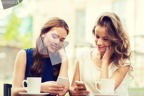 Image of women with smartphones and coffee at outdoor cafe