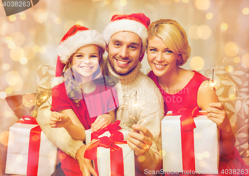 Image of smiling family holding gift boxes and sparkles