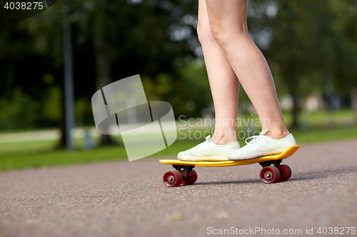 Image of close up of female feet riding short skateboard