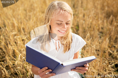 Image of smiling young woman reading book on cereal field