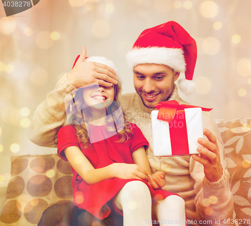 Image of smiling father surprises daughter with gift box