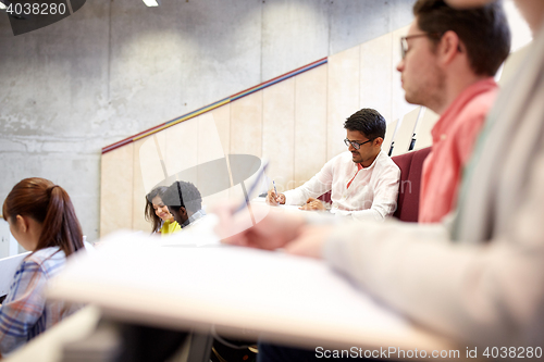 Image of group of students with notebooks in lecture hall