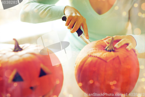 Image of close up of woman with pumpkins at home